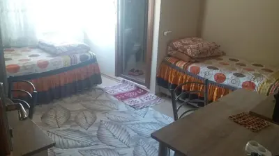 a room with two beds and a table and chairs at Bandirma Saglik Apart in Bandırma