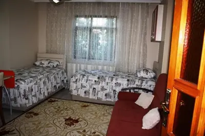 a bedroom with two beds and a window and a couch at Bandirma Saglik Apart in Bandırma
