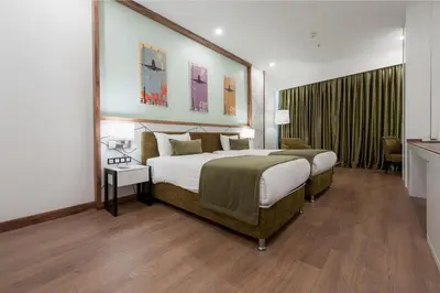 a hotel room with a large bed and a table at ISG Sabiha Gökçen Airport Hotel in Istanbul