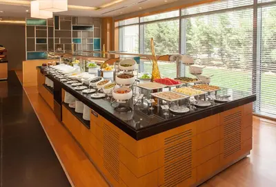 a buffet line in a kitchen with many food at ISG Sabiha Gökçen Airport Hotel in Istanbul