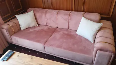 a pink couch with two pillows and a remote control at Hotel Topkapı in Istanbul