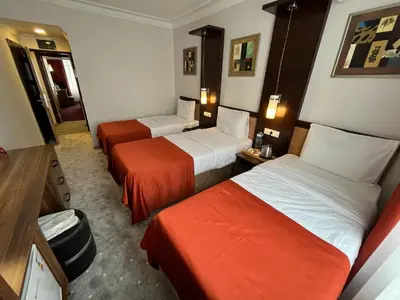 a hotel room with two beds with red sheets at Hotel Topkapı in Istanbul