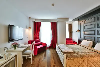 a hotel room with a bed and a desk and red chairs at Senatus Hotel - Special Class in Istanbul