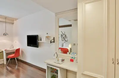 a room with a mirror and a desk with a red chair at Senatus Hotel - Special Class in Istanbul