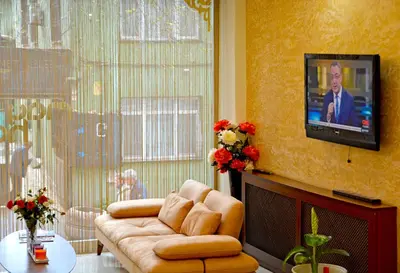 a living room with a couch and a tv on a wall at May Hotel Istanbul in Istanbul