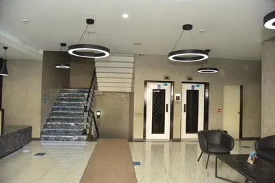 a lobby with a staircase and two doors and chairs at Fuar Hotel in Istanbul