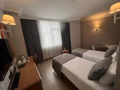 a hotel room with two beds and a television at Fuar Hotel in Istanbul