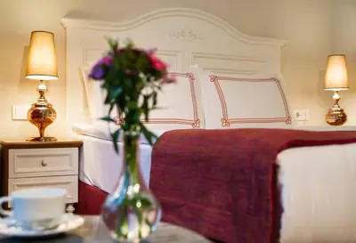 a vase of flowers on a table next to a bed at Amofta Hotel Taksim in Istanbul