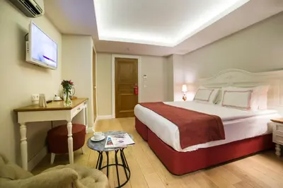 a hotel room with a large bed and a chair at Amofta Hotel Taksim in Istanbul