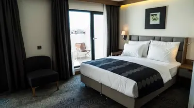a hotel room with a bed and a chair and a window at Yuksel Istanbul Yenikapı Hotel in Istanbul