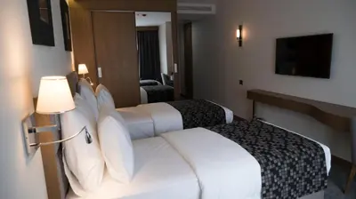 a hotel room with two beds and a television at Yuksel Istanbul Yenikapı Hotel in Istanbul