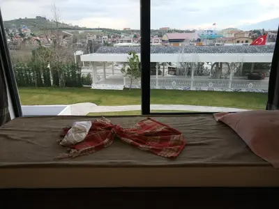 a bow tie sitting on a bed in front of a window at Heybeli Hotel in Mudanya