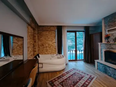 a large bathroom with a tub and a fireplace at Hill River Hotel in Agva