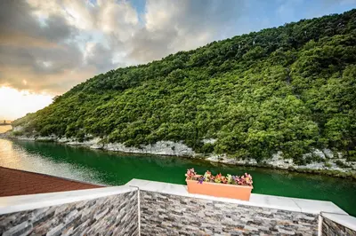 a flower pot on a wall next to a river at Hill River Hotel in Agva