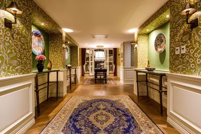 a hallway with green walls and a rug on the floor at Hagia Sofia Mansions Istanbul, Curio Collection by Hilton in Istanbul
