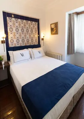 a bedroom with a large bed with blue and white sheets at Cheers Vera Edition Hotel in Istanbul
