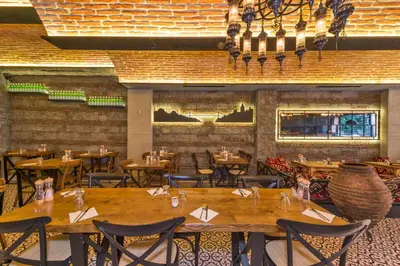 a restaurant with wooden tables and chairs and a brick wall at The Empress Theodora Hotel in Istanbul