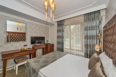 a bedroom with a bed and a desk and a television at The Empress Theodora Hotel in Istanbul
