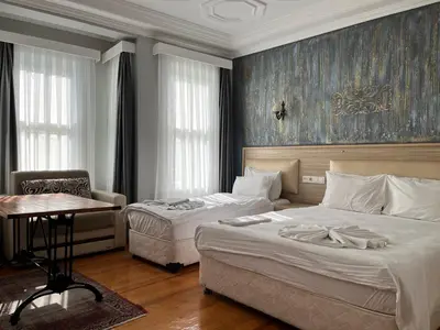 a bedroom with two beds and a table and a chair at Jasmine Apart & Boutique Hotel in Istanbul