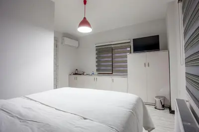 a white bedroom with a bed and a tv at Taksim Sem House in Istanbul