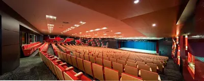 an empty auditorium with orange seats in a theatre at The Green Park Pendik in Istanbul