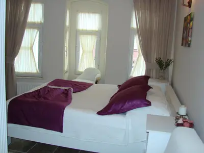 a white bed with purple pillows in a bedroom at Volare Apart in Istanbul
