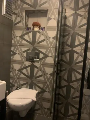 a bathroom with a toilet and a wall at Volare Apart in Istanbul