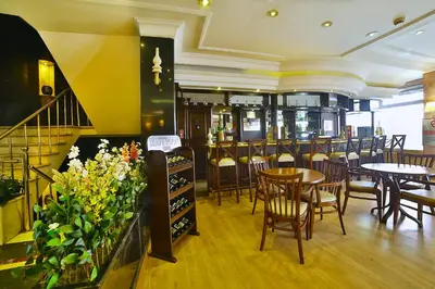a restaurant with wooden tables and chairs and flowers at Hotel Grand Emin in Istanbul