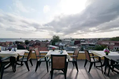 a balcony with tables and chairs and a view of the city at Magnificent Hotel in Istanbul