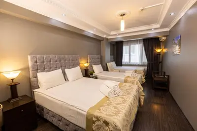 a hotel room with two beds and a couch at Cumbali Luxury Boutique Hotel in Istanbul