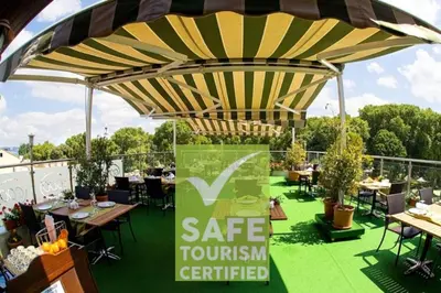 a patio with tables and chairs and a large umbrella at Gülhanepark Hotel & Spa in Istanbul