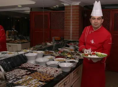 a man in a chefs hat holding a plate of food at Seher HOTEL in Istanbul