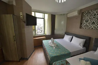 a hotel room with two beds and a television at Omega Luxx Hotel in Istanbul