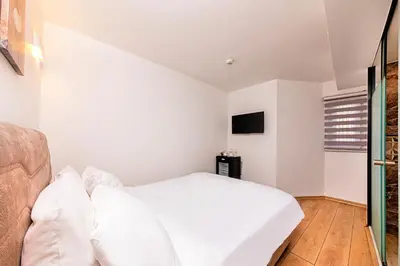 a bedroom with white walls and a bed with white pillows at Neda in Istanbul