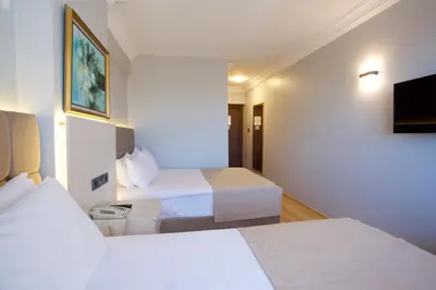 a hotel room with two beds and a flat screen tv at Grand Ant Hotel in Istanbul