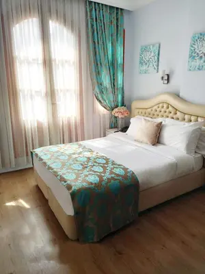 a bedroom with a large bed with blue curtains at Antik Ipek Hotel in Istanbul