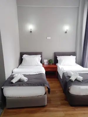 two twin beds in a room with a red table at Antik Ipek Hotel in Istanbul