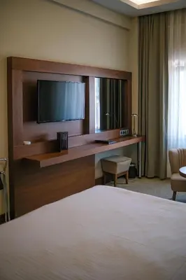 a hotel room with a bed and a desk with a television at Ramada by Wyndham Yalova in Yalova