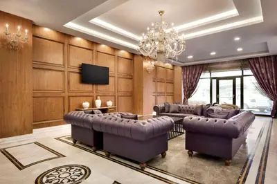 a living room with leather furniture and a chandelier at Ramada by Wyndham Yalova in Yalova