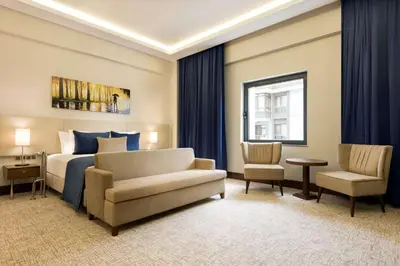 a bedroom with a bed and a couch and a chair at Ramada by Wyndham Yalova in Yalova