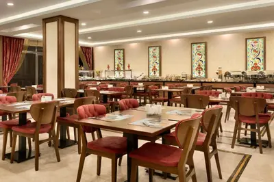 a restaurant with wooden tables and chairs and a bar at Ramada by Wyndham Yalova in Yalova
