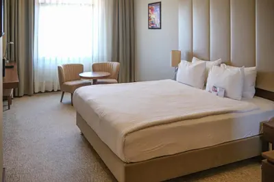 a hotel room with a large bed and a chair at Ramada by Wyndham Yalova in Yalova