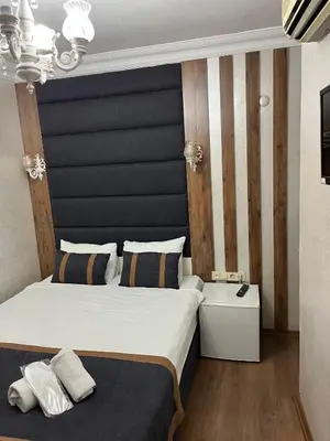 a bedroom with a large bed with a black headboard at Nova Roma Hotel in Istanbul