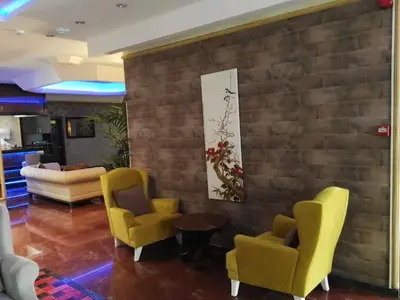 a living room with yellow chairs and a brick wall at Hermanos Hotel in Istanbul