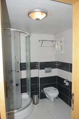 a bathroom with a glass shower and a toilet at Hermanos Hotel in Istanbul