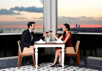 a man and woman sitting at a table with wine glasses at Darkhill Hotel in Istanbul
