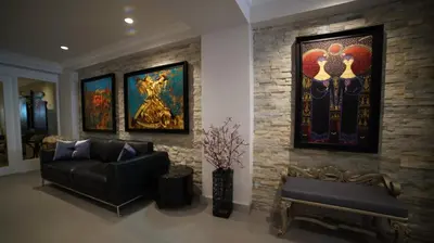 a living room with a couch and paintings on a brick wall at Ascot Hotel Büyükada in Buyukada