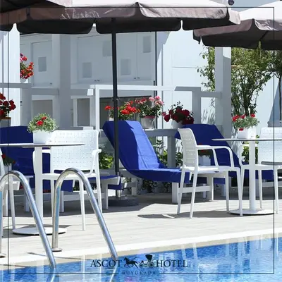 a group of chairs and an umbrella next to a pool at Ascot Hotel Büyükada in Buyukada