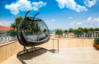 a black chair sitting on top of a balcony at Ascot Hotel Büyükada in Buyukada