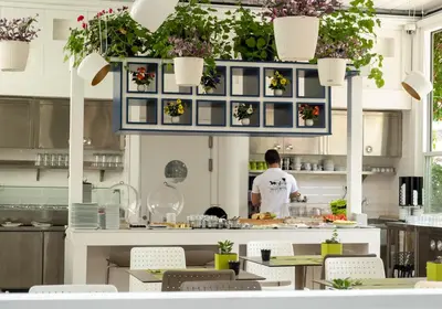 a man standing in a kitchen preparing food at Ascot Hotel Büyükada in Buyukada